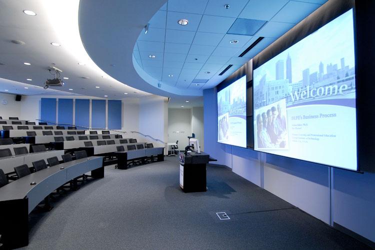Empty amphitheater with presentation displayed on two projector screens